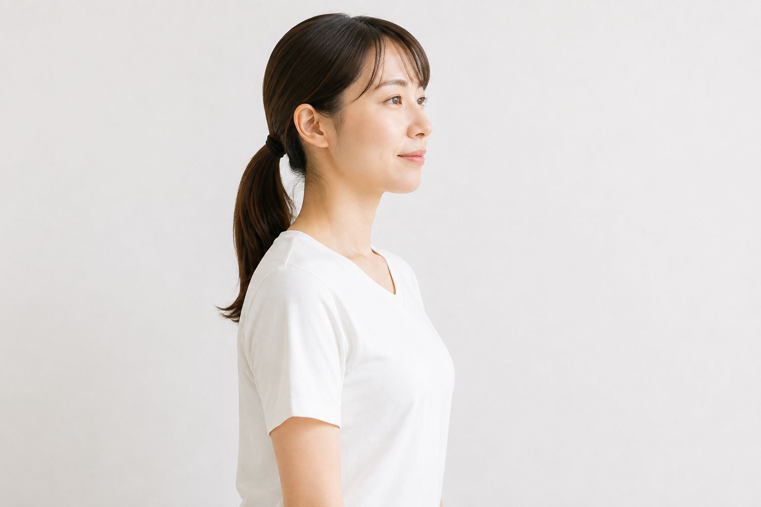 背筋を伸ばして横を向いて立つ女性